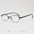 Detailed view of black metal oval eyeglass frame, featuring adjustable nose pads and temple details. - Matte Black Clear Lenses C6