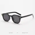 Close-up of retro black polarized sunglasses with metallic rivet detail on clean background. - Glossy Black Frame Grey Lens C7