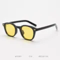 Detail view of vintage black frame sunglasses with vibrant yellow lenses and metal rivet accents. - Glossy Black / Night Vision Yellow C10