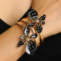 Vintage-Gold-Armreif mit großen schwarz-weißen Polka-Dot-Blumen am Handgelenk. - Schwarz-Weiß Gepunkteter Blumenarmreif (3508)