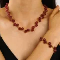 Detailed view of vintage red beaded necklace and matching bracelet set on model - Necklace and Bracelet Set