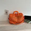 Large capacity orange travel duffel bag with adjustable shoulder strap and front mesh pocket. - Orange