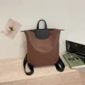 Zaino casual in nylon marrone con patta in pelle nera ideale per il tragitto giornaliero. - Cioccolato