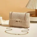Close-up detail of the stylish straw woven crossbody shoulder bag with chic gold chain and lock. - Off White