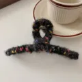 Nahaufnahme einer flauschigen schwarzen Haarklammer mit bunten Punkten für den Alltag. - Haarklammer-Stil / Schwarzes Kunstfell
