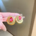 Vintage gold-toned clip-on earrings with pink rhinestone and crystal halo, variant detail view. - #13 Silver Needle Earrings - Gold-Tone Oval Zirconia