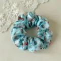 Scrunchie natalizio in raso blu con stampe di fiocchi di neve e regali per acconciature chic. - Pupazzo di Neve Blu