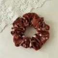 Detailed view of brown Christmas hair scrunchie with cute holiday snowflake and reindeer prints. - Wine Red Elk