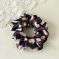 Dettaglio ravvicinato di un elastico per capelli nero con stampa di Babbo Natale. - Babbo Natale Nero