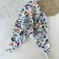 Nahaufnahme eines vintage Blumenmuster Dreiecktuchs, ideal als modisches Haarband genutzt. - Weiß Blumenmuster Dreieck