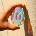 Detail shot of a large crystal suncatcher teardrop pendant refracting colorful rainbow light. - 89mm Longan Shape