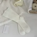 Cozy cashmere winter socks in solid off-white with classic vertical ribbed knit texture. - One Size / White