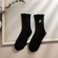Schwarze Damen Socken mit süßer weißer Gänseblümchen Stickerei und Rüschenrand. - Schwarz