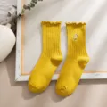 Süße gelbe Mittelsocken mit filigranem Gänseblümchen-Stickmuster und Rüschenbündchen. - Gelb
