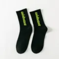Black mid-tube socks with neon green Calabasas letters, streetwear trendy skate hosiery. - One Size / Crew Socks / Black