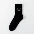 Chaussettes mi-mollet en coton noir pour femmes avec visage souriant et motif tricoté. - Taille unique / Visage souriant sur bordure noire