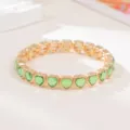 Close-up view of the green heart crystal and gold-tone metallic bracelet detail, elegant style. - Green Heart Rhinestone Style (SL1574)