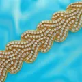 Close-up detail of sparkly rhinestone crystal trim applique for wedding dress belt or evening gown. - Gold