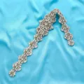 Detailed shot of sparkling rhinestone floral applique for bridal dress and DIY sash design. - Gold