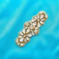 Detailed shot of rhinestones and pearls on a floral applique, perfect for bridal gown embellishment. - Gold