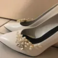 Detail view of handmade pearl rhinestone shoe clips on elegant white bridal high heels. - Pair of Shoe Charms