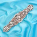 Close-up detail of a stunning rose gold bridal rhinestone belt applique with crystal and pearls. - Rose Gold