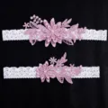 Elegant white lace garter set with pink embroidered floral appliques and pearls for brides. - Lotus Pink