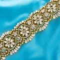 Close-up detail of luxury rhinestone applique crystal wedding belt trim with sparkling stones. - Gold