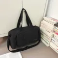 Black large capacity travel duffel gym bag with shoulder strap and front zipper pocket. - Black