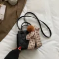 Schicke schwarze gesteppte Handtasche mit Plüsch-Bommel und Schal, modische Umhängetasche. - Schwarz