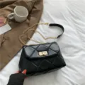 Schwarze gesteppte Leder-Umhängetasche mit goldener Kette, stilvolles minimalistisches Design. - Schwarz