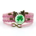 Primo piano del bracciale in pelle intrecciata rosa con cabochon in vetro con trifoglio fortunato. - Stile Quadrifoglio Coccinella Good Luck (2) / Rosa
