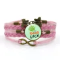 Bracciale in pelle intrecciata rosa con cabochon in vetro trifoglio e ciondoli in bronzo. - Stile 10 / Rosa