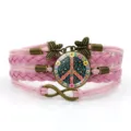 Bracciale in pelle intrecciata multistrato rosa con segno della pace e ciondoli a farfalla. - Rosa Stile 12
