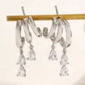 Detailed macro view of silver-tone irregular hoop earrings with pear-cut zircon pendants - Waterdrop Dynamic Hoop (X051)