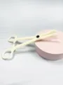 Close-up of acrylic body piercing auxiliary tool, beige closing plier detail for professional use. - Round Nose Ring Opening Pliers