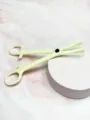 Close-up detail view of the yellow plastic body piercing clamp tool, auxiliary closing design. - Triangle Slotted Pliers