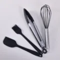 Black 4-piece silicone baking utensil set including spatula, brush, tongs, and whisk. - Black 4-Piece Baking Set A
