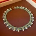 Handgemaakte kralenketting detail, met turquoise zaadkralen, goudkleurige accents en witte druppelparels. - Goud-Blauw-Wit