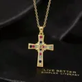 Gedetailleerde close-up van een vintage vergulde kruishanger met kleurrijke zirkonia's. - Kruis Ketting / Goud