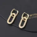 Nahaufnahme von goldenen ineinandergreifenden Zirkonia Creolen, modernes minimalistisches Detail. - Ineinandergreifender Doppelring Gold Stil (A)