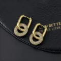 Primo piano di orecchini geometrici dorati con strass intrecciati e una lucentezza raffinata. - Stile a Strati a Doppio Anello a U (G)