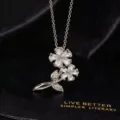 Primer plano detallado del collar con colgante de doble flor de circonita cúbica. - Estilo De Doble Flor (X)