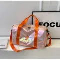 Schicke, schillernde Sporttasche in Rosa mit orangefarbenen Trägern, grosses Fitness-Reisegepäck. - Orange