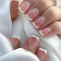 Primo piano di unghie finte con sfumatura glitter rosa e punte francesi bianche. - Rosa Oro Francese