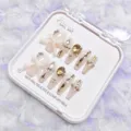 Detalle cercano de uñas postizas largas de lujo con lazos blancos y cristales brillantes. - L / Diseño de Moño de Lujo / Caja de Plástico Con Juego de Herramientas de 5 Piezas