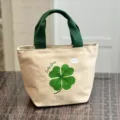 Canvas lunch bag with green handles and lucky grass clover print for daily meals. - Lucky Clover / Khaki