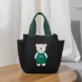 Leuke zwarte canvas lunchtas met groene handvatten en een schattige berenprint. - Zwart
