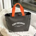Stylish grey oxford cloth tote bag with vibrant orange handles and daily commuter bento design. - Large Gray Letter Style
