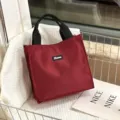 Red minimalist lunch tote bag with black handles and front label, spacious and stylish. - Red